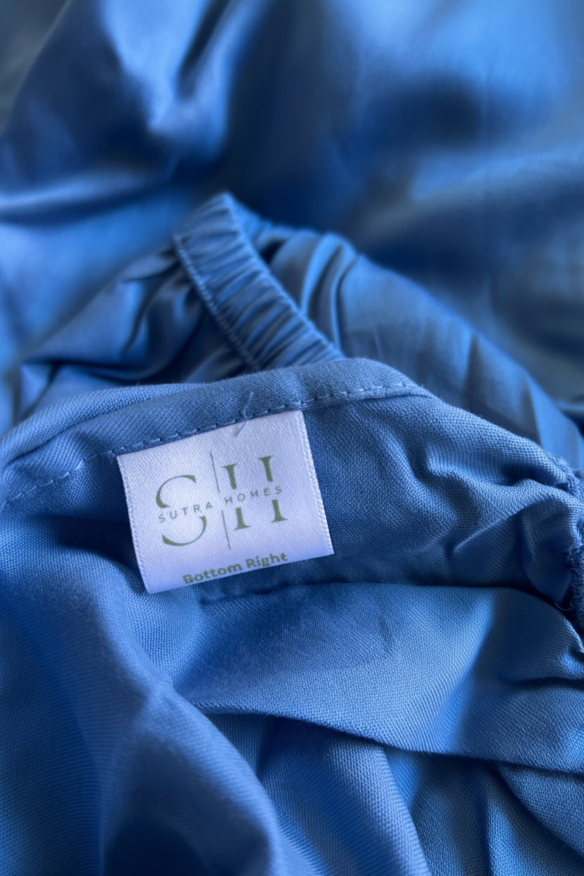 A close-up of a cobalt blue fitted sheet to showcase 3/4 inch of the elastic & the stitching