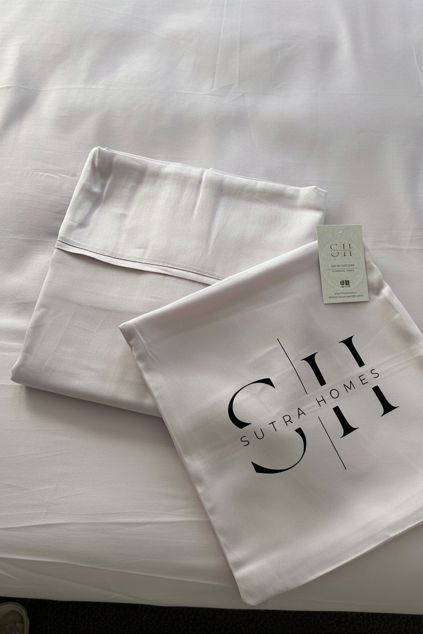 Soft-muted lilac/ lavendar colour  pillowcase on the matching sheet, with the brand name 'SUITABLE HOMES' printed in black on the pillowcase and a small product tag attached.